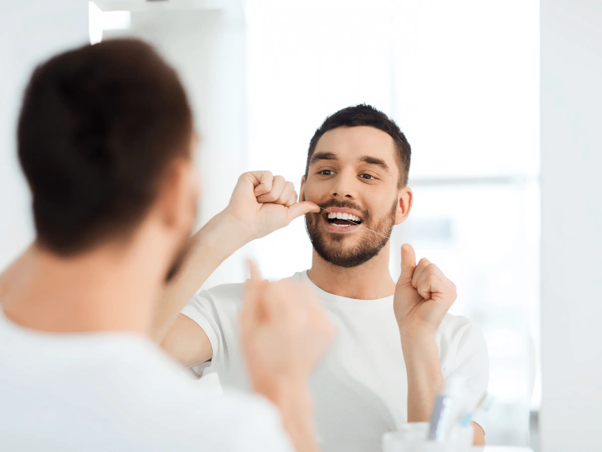 hombre usando hilo dental